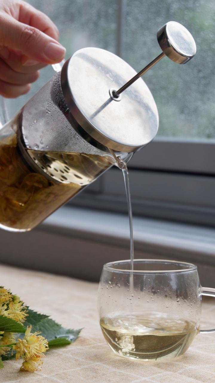 Ihlamur dökülen bir bardak görseli, fransız demleme ile bitki çayı yapımı
